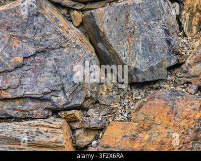 Natural mountain rock texture with rugged geological patterns, weathered stone, earthy tones and authentic mineral details for premium backgrounds. Stock Photo