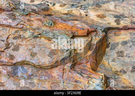 Natural mountain rock texture with rugged geological patterns, weathered stone, earthy tones, authentic mineral details for premium backgrounds Stock Photo