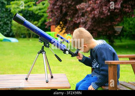 Boy looking through a telescope. Stock Photo