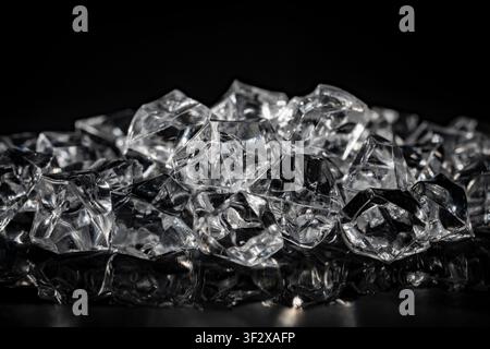 Close up of artificial acrylic ice cubes with glowing highlights on dark glossy surface for cold beverage and luxury product commercial advertising Stock Photo