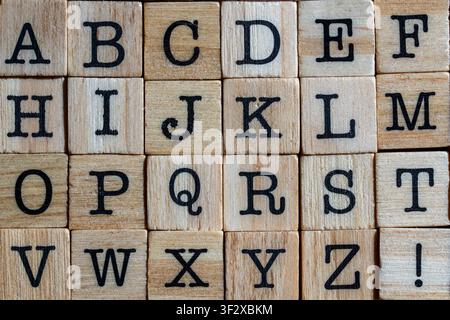 English alphabet on wooden blocks background, close up. Top view of english abc letters printed on wooden cubes arranged in rows. Education, preschool Stock Photo