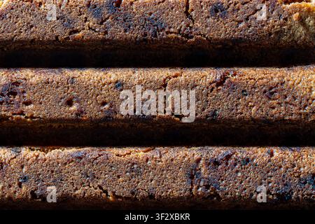 Brown biscuit texture close up full frame background. Macro view of chocolate or gingerbread sponge cake slices background. Soft porous texture of bak Stock Photo