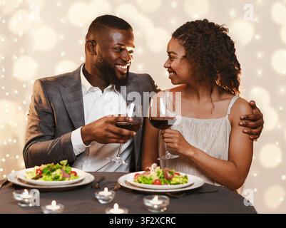 Young black couple having festive dinner at restaurant Stock Photo