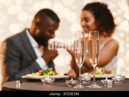 Black man and woman having romantic date at restaurant Stock Photo