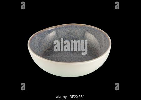 Blue speckled ceramic bowl photographed on a black background, empty and centered for product display; minimalist stoneware tableware ideal for food s Stock Photo