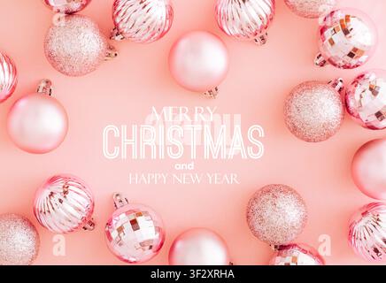 Pink Christmas baubles frame on pastel pink background with text. Christmas and New Year concept. Creative festive holiday backdrop. Stock Photo