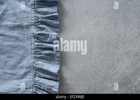 Blue linen kitchen napkin on gray stone background with copy space. Minimal textile background for table setting and home decor. Stock Photo