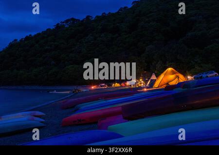 Koan Camping Ground, located on the shore of Lake Motosu in Yamanashi Prefecture, offers a scenic outdoor experience. The campsite features tent space Stock Photo