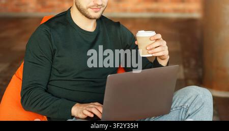 Unrecognizable Guy Using Laptop Sitting On Beanbag Chair Indoor, Panorama Stock Photo