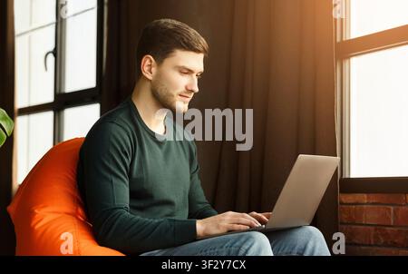 Freelancer Man Using Laptop Sitting In Workspace Indoor Stock Photo