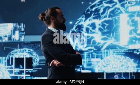 Male entrepreneur works on implementing AI brain system for deep learning, employing neural networks and cybernetics for growth. Using smart technology and algorithmic thinking. Camera A. Stock Photo