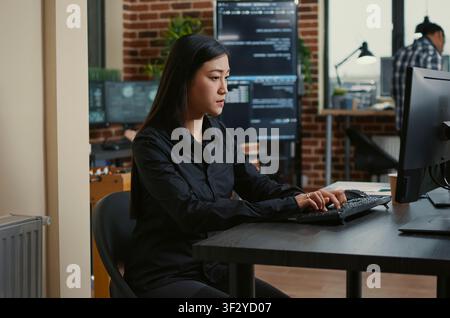 Software developers collaborate at the desk while reviewing source code, discussing algorithms and working together on a cloud computing project. Stock Photo