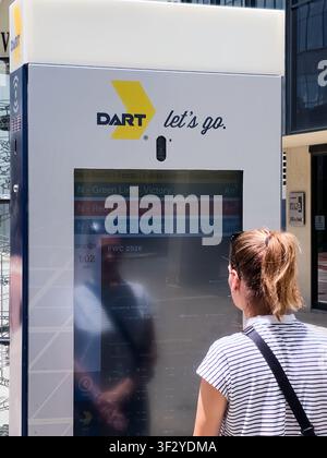 DALLAS, TX, USA - JULY 11, 2026: A person interacts with a DART transit information kiosk displaying schedules for various lines in Dallas. DART, or D Stock Photo