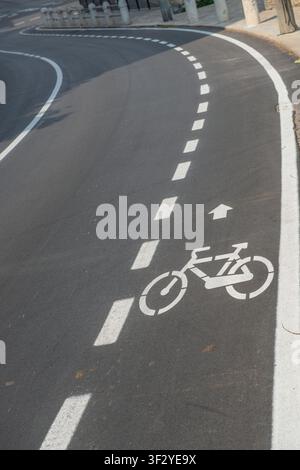 Bicycle lane with clearly visible white road markings on the asphalt Stock Photo