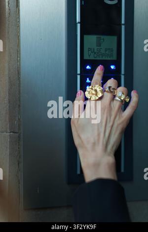 Hand pressing button on modern intercom Stock Photo