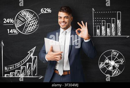 Successful muslim businessman with digital tablet showing okay Stock Photo