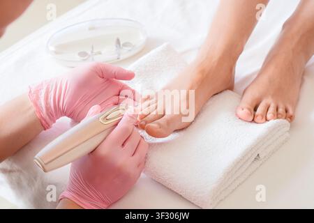 Pedicure treatment on a womans foot with a nail file, beauty and personal care, spa and salon service Stock Photo