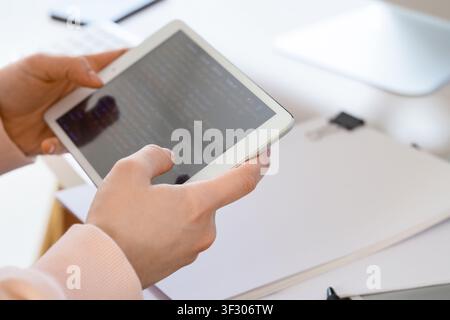 Female programmers hands testing code on tablet computer in office, closeup Stock Photo