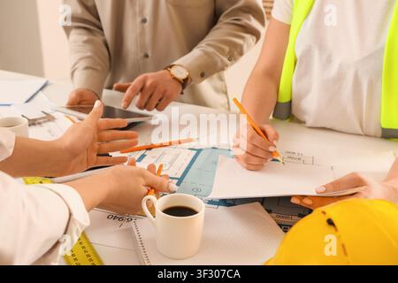 Team of constructors working at table in room, closeup Stock Photo