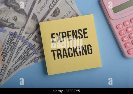 Expense tracking concept with sticky note, dollar bills and calculator on blue background, symbolizing budgeting, financial control, personal finance Stock Photo