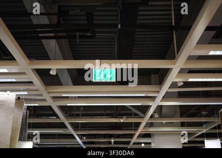 Exit sign is visible on the ceiling in a store Stock Photo
