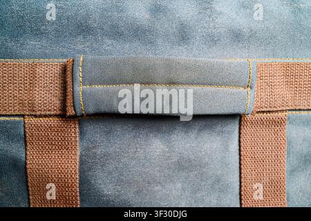Macro view of a canvas bag handle and brown webbing straps with detailed yellow stitching. Close-up shot showing fabric texture and construction detai Stock Photo