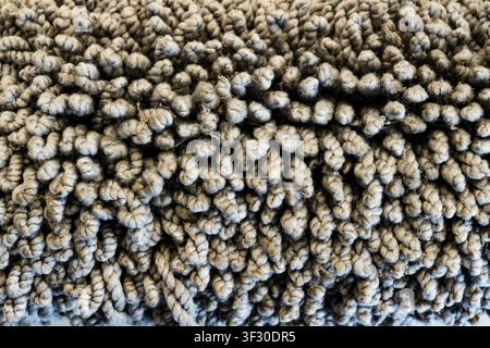 Detailed macro shot of a grey shaggy carpet or rug showing twisted fabric fibers. Ideal for textile backgrounds, interior design, and home decor conce Stock Photo