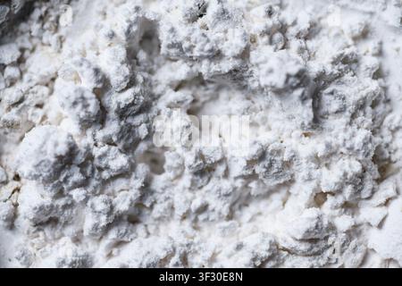 High-resolution macro shot of white powder texture with uneven surface, clumps, and circular patterns. Perfect for abstract backgrounds or representin Stock Photo
