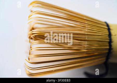 High-angle macro shot of a traditional Japanese bamboo matcha whisk, showing intricate details of the tines and central core. Ideal for tea ceremony a Stock Photo