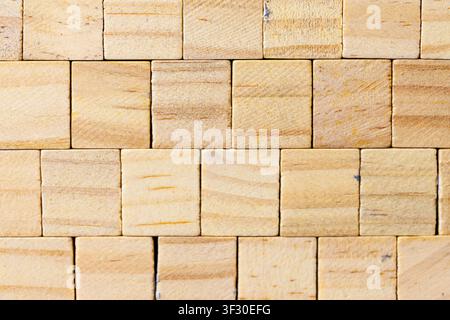 Close-up of small light brown wooden blocks arranged in a staggered grid pattern. The natural wood grain texture is highly detailed, making it ideal f Stock Photo