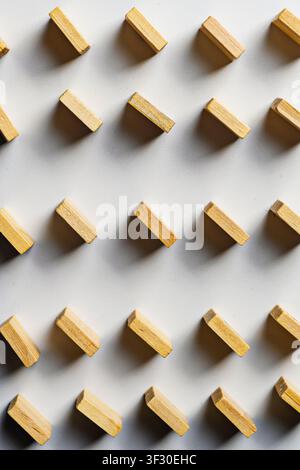 High-angle view of small wooden rectangles arranged in a diagonal grid pattern on a clean white surface. Perfect for background, design concepts, and Stock Photo