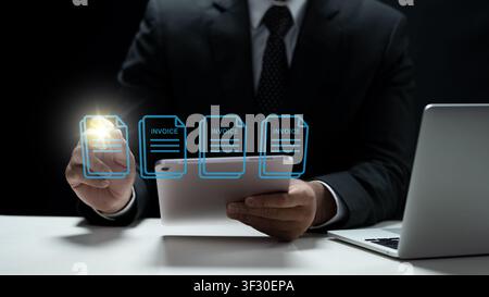 A professional businessman in a suit uses a tablet to manage electronic invoices, representing digital billing, accounting software, and paperless off Stock Photo