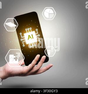 A hand holds a smartphone showing a glowing AI chip icon surrounded by technology symbols for data analysis, machine learning, and automation on a cle Stock Photo