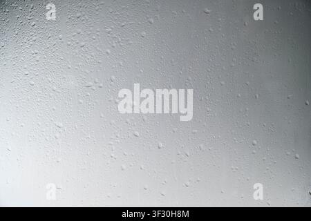A close-up view of a gray painted surface featuring vertical liquid streaks and drips, creating a grunge industrial background for design projects Stock Photo