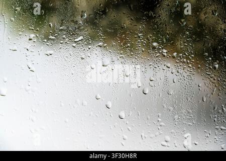 A close-up view of a gray painted surface featuring vertical liquid streaks and drips, creating a grunge industrial background for design projects Stock Photo