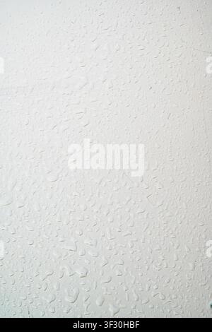 A close-up view of a gray painted surface featuring vertical liquid streaks and drips, creating a grunge industrial background for design projects Stock Photo
