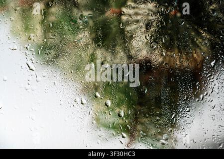 A close-up view of a gray painted surface featuring vertical liquid streaks and drips, creating a grunge industrial background for design projects Stock Photo