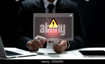A professional man in a suit faces a digital 404 access denied warning on his smartphone. Concept of cybersecurity, server issues, and data protection Stock Photo