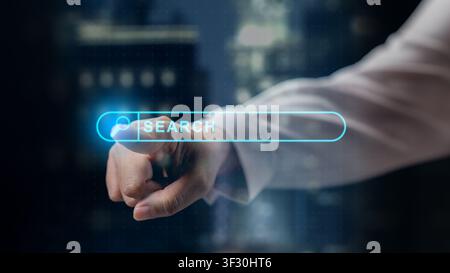 Finger interacting with a glowing futuristic search bar icon on a digital screen, set against a blurred city background. Concept of internet browsing, Stock Photo