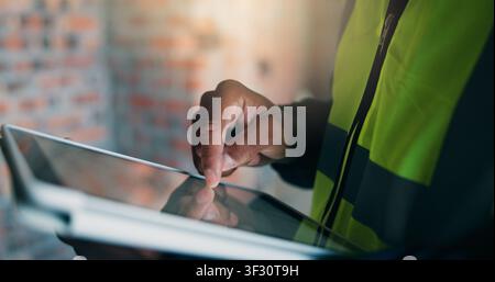 Man, tablet or hands at construction site for planning, building renovation or development. Engineer, tech or scroll at worksite for project Stock Photo