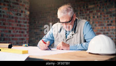 Man, architect or blueprint at construction site for drawing, design update and planning renovation. Mature engineer, floorplan or paper at worksite Stock Photo