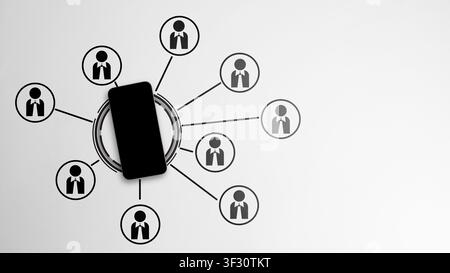 Minimalist top-down view of a black smartphone acting as a central hub connected to multiple person icons, symbolizing digital networking, social medi Stock Photo