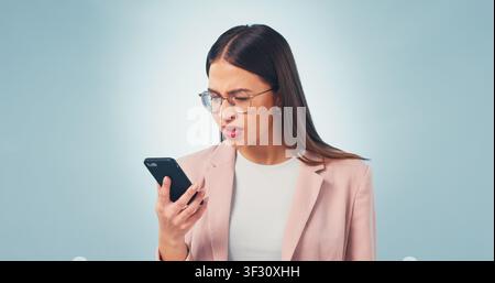 Confused, businesswoman and reading in studio with phone, online glitch or notification of email scam. Space, person and concern with tech, suspicious Stock Photo