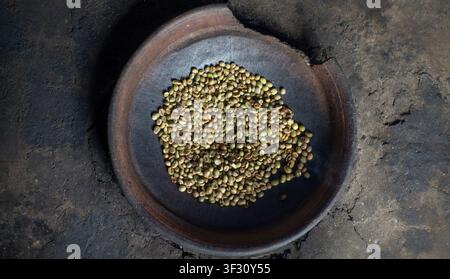 Green Coffee Beans on Traditional Clay Plate Top View Stock Photo