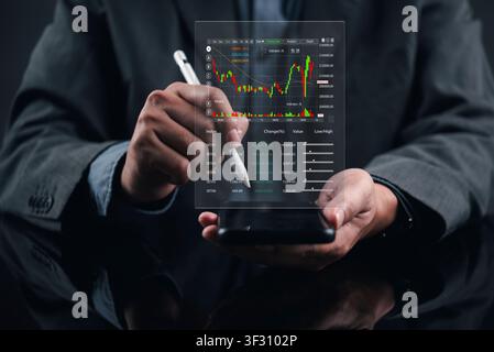Businessman holding smartphone and stylus with virtual stock market trading chart hologram. Concept of mobile financial investment, fintech applicatio Stock Photo