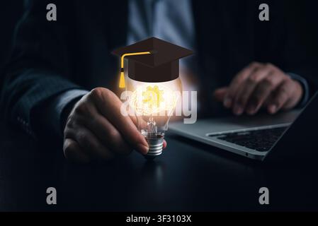 Businessman holding glowing lightbulb with AI brain and graduation cap. Concept of artificial intelligence in education, smart learning, edtech innova Stock Photo