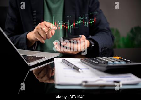 Businessman holding smartphone with digital stock market candlestick chart. Mobile trading concept, financial investment strategy, forex crypto analyt Stock Photo