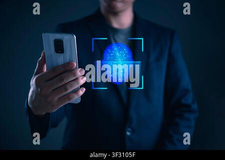 Businessman using futuristic facial recognition technology on smartphone for biometric authentication. Cyber security, digital identity verification, Stock Photo