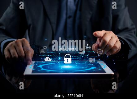 Businessman using tablet with Zero Trust security interface, padlock icon, and network protection shield. Concept of cybersecurity, data privacy, clou Stock Photo