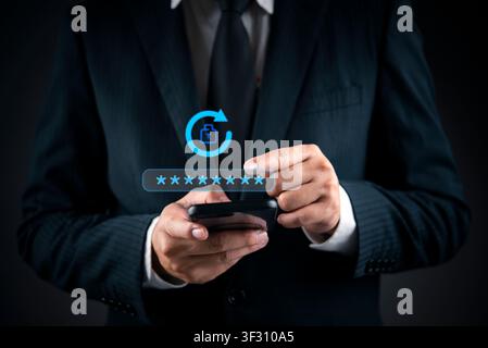 Businessman hand using smartphone with virtual password reset icon. Concept of changing password, account recovery, security update, and cyber hygiene Stock Photo